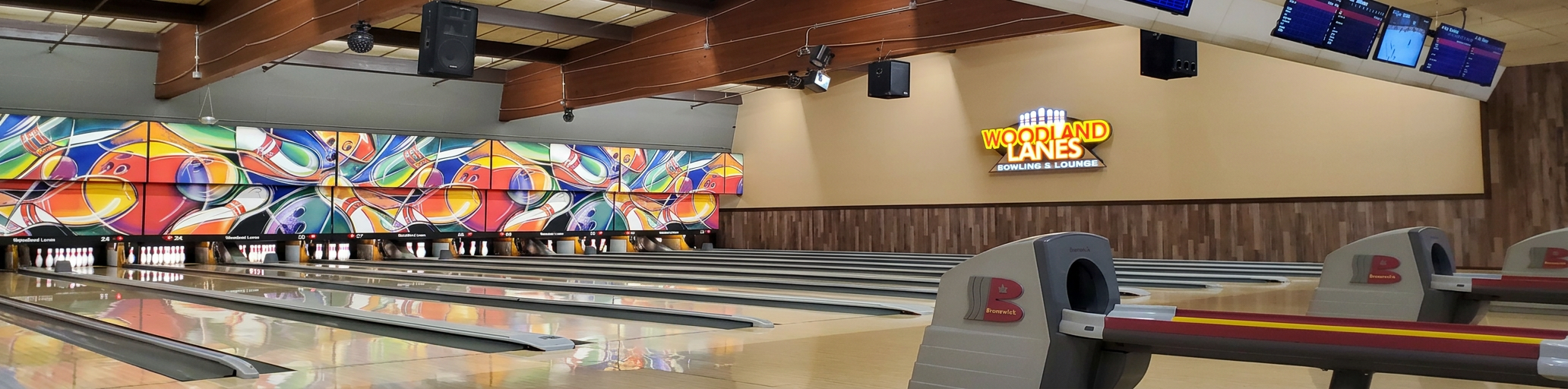 The lanes at Woodland Lanes in Livonia, with the Woodland Lanes sign lit above the pin decks
